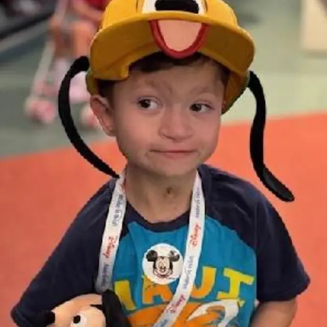 A wish kid wearing a firefighter costume
